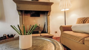 Un salon chaleureux avec une cheminée, un canapé, une lampe et un plateau décoratif.