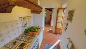 Une cuisine équipée d’une cuisinière, d’un évier et de poutres en bois au plafond.