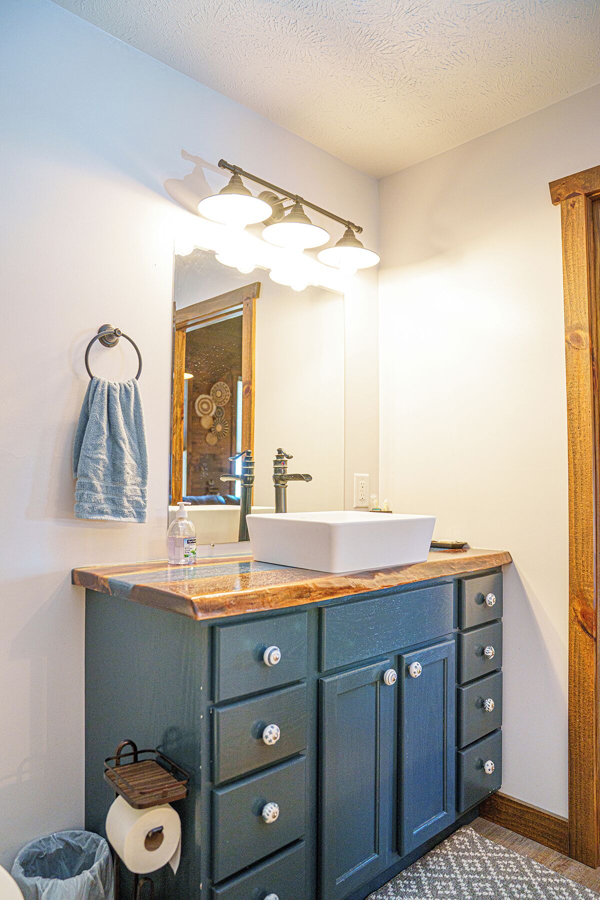 A bathroom with a white sink, a mirror, and a towel rack.