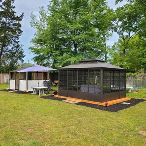 Enjoy shaded playtime in the enclosed playhouse or relax under the gazebo in this serene backyard oasis.