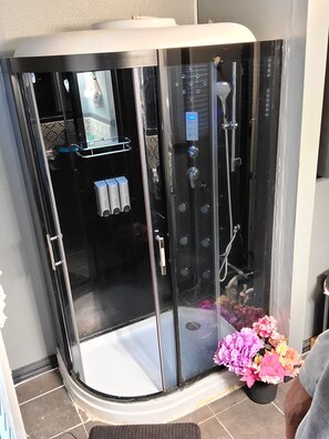 Enjoy a versatile bathing experience with a shower featuring multiple water jets and a handheld showerhead.