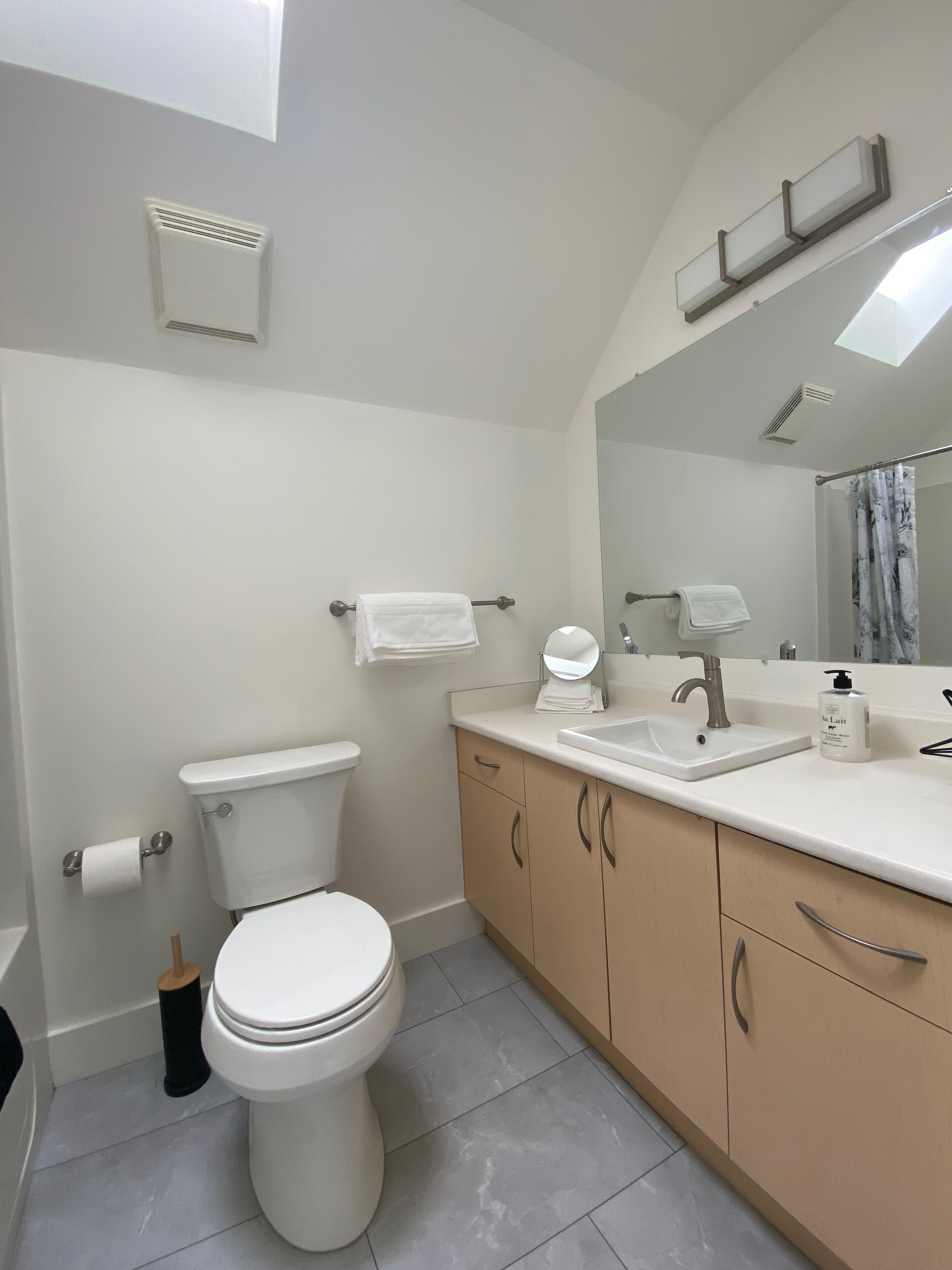Une salle de bain moderne équipée de toilettes, d’un lavabo et d’un meuble-lavabo.