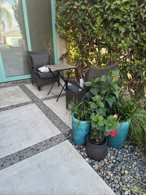 An outdoor seating area with a table and chairs, surrounded by potted plants and a stone pathway. - eos Haus :Architect-Designed Private Suite • 1 Mile to Ocean Beach (San Diego)