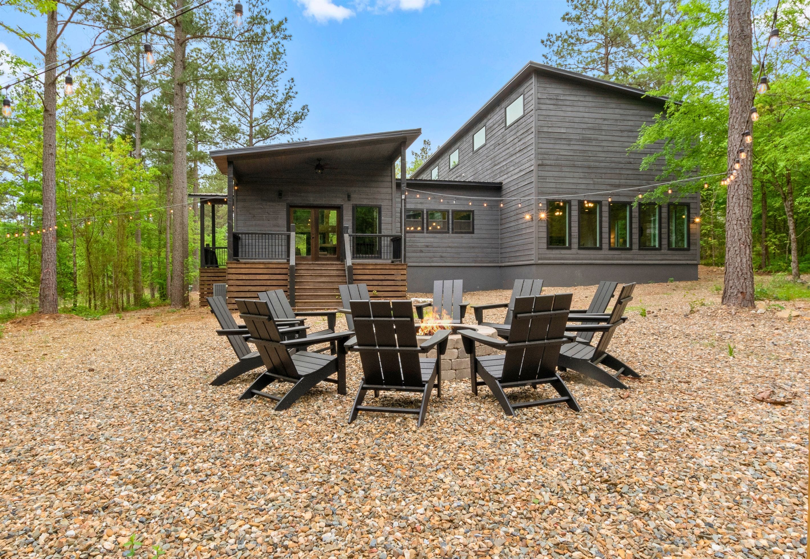 Ein modernes Blockhaus mit einer Terrasse und einer Sitzgelegenheit im Freien.