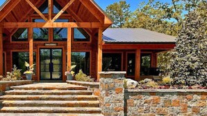 A lodge with a prominent wooden structure and stone steps leading to the entrance. - Luxury Mountain Cabin Retreat in Broken Bow (Broken Bow)