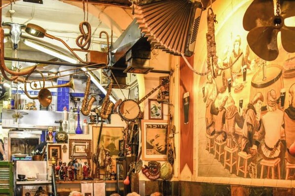 Una habitación con varios instrumentos musicales y un mural de figuras sentadas.