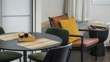 Un comedor con una mesa redonda, sillas y una mesita auxiliar con libros.
