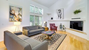 A living room with a sofa, armchair, coffee table, and artwork on the walls. - Granger Gathering Place, 4 Mi to Notre Dame (Granger)