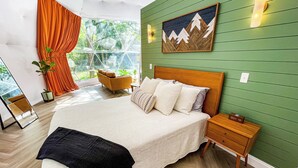 A bedroom with a large bed, a nightstand, a wooden headboard, a green wall, a window with curtains, and a painting. - Stargazing Geodome Retreat Outdoor Tub + Mountain View’s (Madisonville)