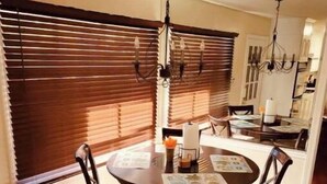 Un coin repas avec une table ronde, quatre chaises et un lustre.