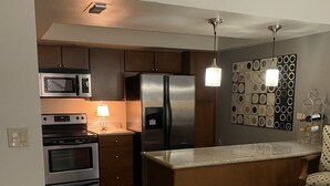 Eine moderne Küche mit Edelstahlgeräten, einer Holzinsel und einer Wand mit Muster.