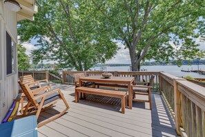 A wooden deck with a table and chairs, overlooking a lake. - Pet-Friendly Lake Norman Home with Boat Dock! (Mooresville)