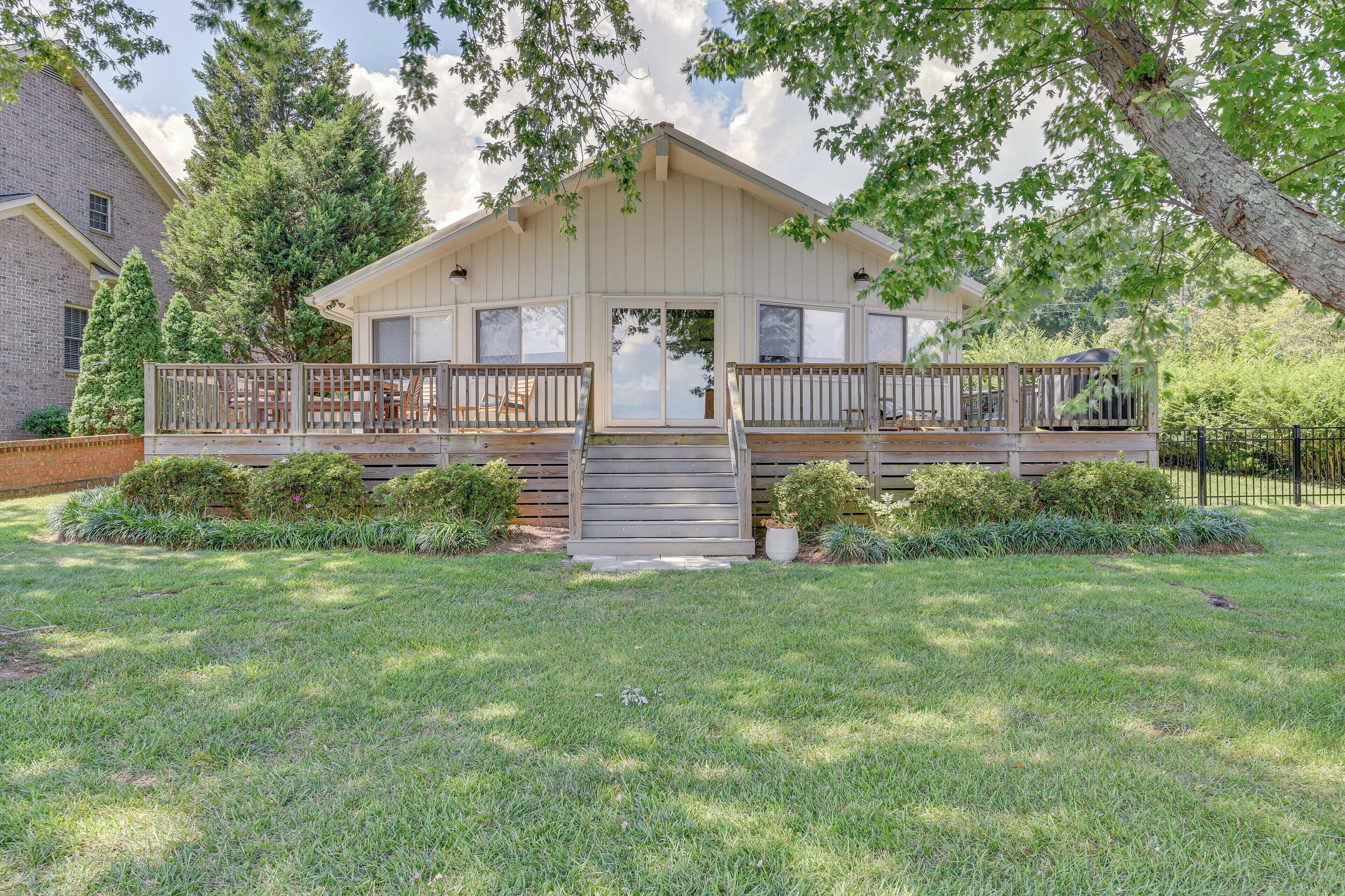 A two-story house with a front porch, a covered deck, and a well-maintained lawn.