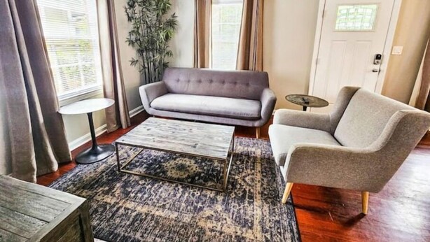 Un salon comprenant un canapé, un fauteuil, une table basse et une petite table d’appoint.