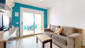 A modern living room with a sofa, a coffee table, and a TV on a cabinet. - Pet friendly apartment in Oropesa del Mar (Oropesa del Mar)