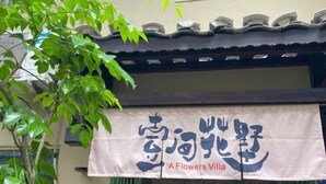 Ein Gebäude mit einem Schild, das auf Englisch und Chinesisch 'A Flowers Villa' zeigt.