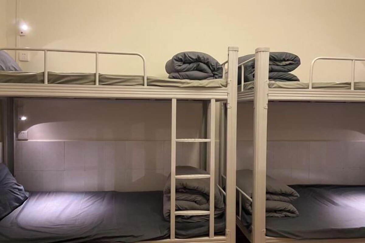 Habitación con literas, dos camas, cada una con almohada y manta.