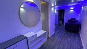 Una habitación moderna con un espejo redondo, una cama y una mesita.