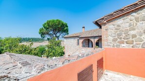 Un bâtiment en pierre avec un toit en tuiles et un mur orange.