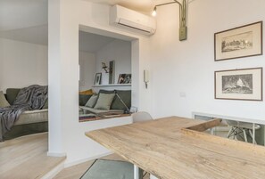 A living room with a wooden table, a sofa, and a bookshelf.