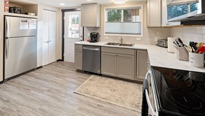 Una cucina moderna con frigorifero, lavastoviglie, piano cottura e lavello.