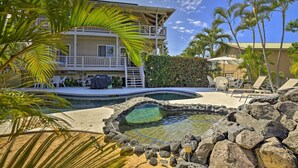 A pool area with a hot tub, lounge chairs, and a building with a balcony. -  Walk to White Sands Beach   Ocean view 2 Bedroom with pool (Kailua-Kona)