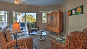 A spacious living area with wicker furniture, a ceiling fan, and a view of the outdoors. -  Walk to White Sands Beach   Ocean view 2 Bedroom with pool (Kailua-Kona)