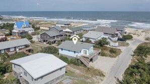 Et kystnært boligområde med huse, en strand og udsigt over havet.