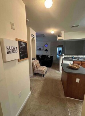 Cozy living space with a seating area, kitchen, and dining area, featuring a minimalist design.
