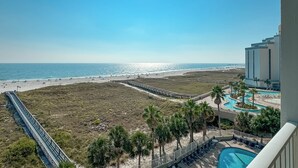 Een resort met zwembad, strand en uitzicht op de oceaan.