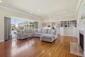 A spacious living room with a sectional sofa, a coffee table, and a fireplace.