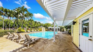 A pool area with lounge chairs, a covered patio, and a view of the pool. - Updated 1 bedroom in paradise! (Waikoloa Village)
