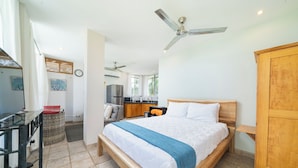 A bedroom with a bed, wooden wardrobe, and a ceiling fan. - Beachfront Villa Elysian Sol Suite Sleeps 3 (Provincia de Guanacaste)