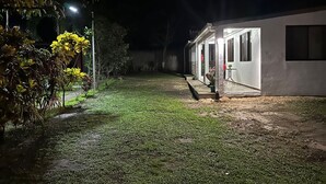 A nighttime view of a building with a covered outdoor area, a pathway leading to the entrance, and some greenery. - Villas Winara With Private Pool and Close to Amazing Waterfalls (Curubandé)
