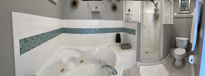 Tina de hidromasaje, toallas, papel de baño