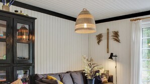 Un salon moderne avec un canapé gris, une table basse ronde en bois et un fauteuil en osier.