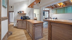 Una cocina con encimeras de madera, una cafetera y un lámpara colgante.