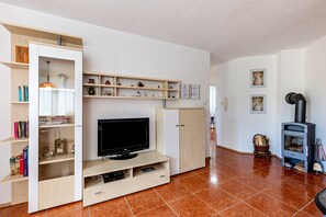 Uma sala de estar com televisão, estantes, um armário e lareira.