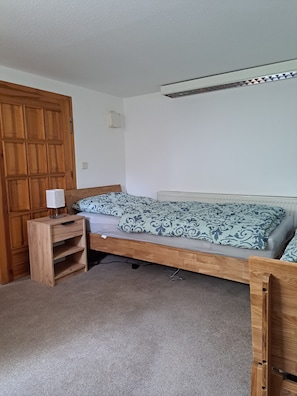 Ein Schlafzimmer mit einem Holzbettgestell, einem Nachttisch mit Lampe und einem Kleiderschrank.