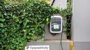 Estación de carga eléctrica montada en la pared, con indicación de que es para vehículos eléctricos.