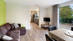 Una sala de estar moderna con un sofá, una mesa de comedor y un televisor.