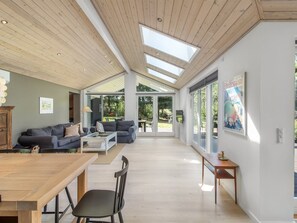 Un vaste espace de vie doté d’un haut plafond, de grandes fenêtres et offrant une vue sur l’extérieur.
