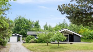 A modern two-story house with a covered porch and a garage.
