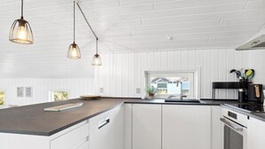 A modern kitchen with white cabinetry, a dark countertop, and pendant lighting. - "Blaguna" - 600m from the sea by Interhome (Thisted)