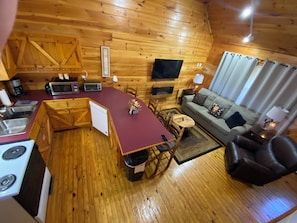 Ein gemütliches Blockhaus mit Küche, Essbereich und Wohnzimmer.