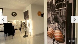 Una habitación con comedor, un ventilador y un reloj de pared.