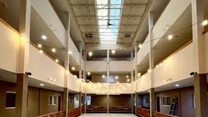 A spacious atrium with a high ceiling, multiple floors, and a central open area.
