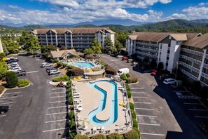 Ein Hotel mit mehreren Gebäuden, einem Schwimmbad und einem Parkplatz.