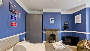 A hotel room with a bed, a fireplace, a television, and a basketball hoop. - Twickenham Green (Twickenham)