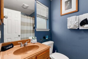 Een bad/douchecombinatie, een haardroger, handdoeken, shampoo